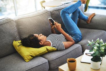 Woman looking at her phone on the couch