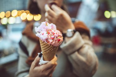 girl with pink ice cream and sprinkles in a cone