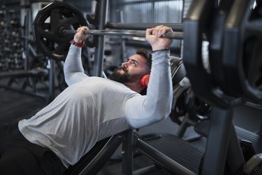 Man Doing the Bench Press In Gym as Part of an Upper-Body Superset