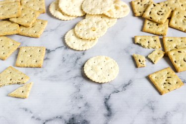 Matzo crackers, salty crackers with sesame seeds and flax seeds on a light background.