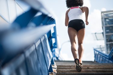 Sporty woman running upstairs - fitness concept