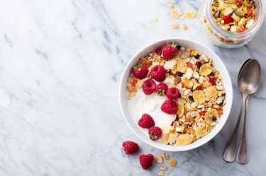 Healthy breakfast. Fresh granola, muesli, yogurt, berries on marble background. Top view. Copy space