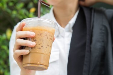 a man drinking iced coffee