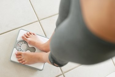Low section of a girl weighing herself