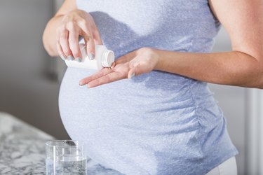 Pregnant woman taking pill