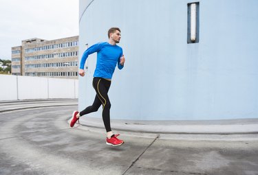 Young man doing a HIIT running workout in the city