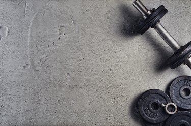 Fitness or bodybuilding background. Dumbbells on gym floor, top view