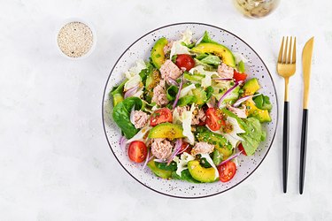 Tuna fish salad with lettuce, cherry tomatoes, avocado and red onions. Healthy food. French cuisine. Top view, copy space, flat lay