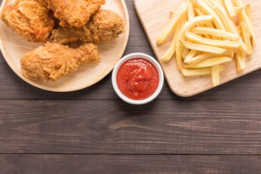 Fried chicken and french fries on a wooden background