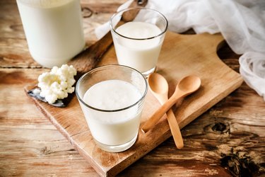 Probiotic-rich Kefir Grains In Wooden Spoon With Glass Of Kefir