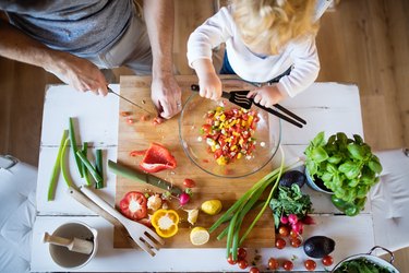 Overhead view of young father with a toddler boy cooking together in the kitchen