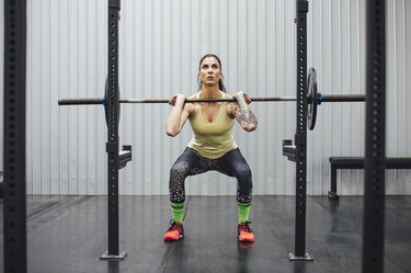 Confident woman lifting deadlift in gym