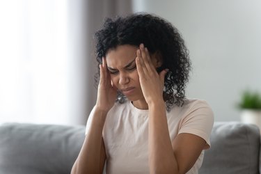 Woman touches temples, reduces sharp headache