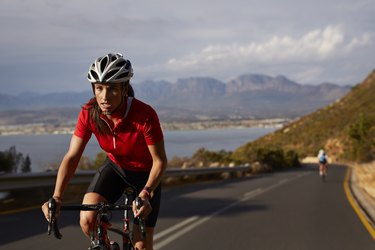 Female pro cyclist taking lead on mountain climb