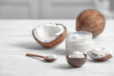 Fresh coconut oil and nuts on wooden table