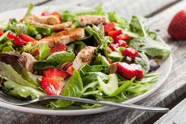 Side view of a leafy green salad with strawberries and grilled chicken are good for the MIND DASH diet