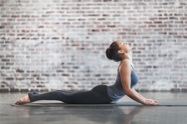 woman doing cobra yoga pose to get rid of back pain after exercise