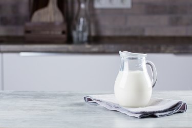 Jug of milk on concrete table background on the kitchen. Dairy Product. Copy space