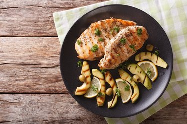 Grilled turkey breast with avocado, lemon and olive close-up. horizontal top view