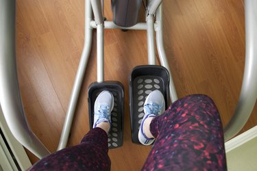 Sneakers and workout clothes on legs using the elliptical