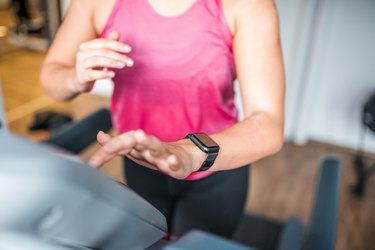 Young woman running on the treadmill in the gym