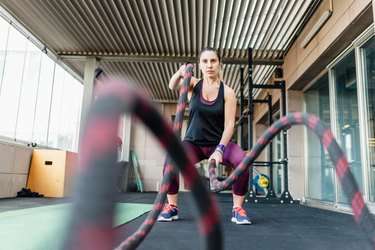 Woman using training rope for sweating workout at sweat it off fitness gym