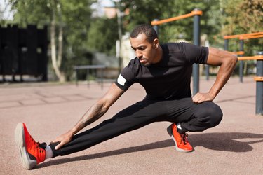 Man stretching outdoors as part of his workout cooldown