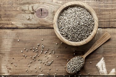 cannabis seeds in a plate and spoon on a wooden background