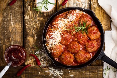 Meatballs in sour tomato sauce with grated parmesan cheese on top