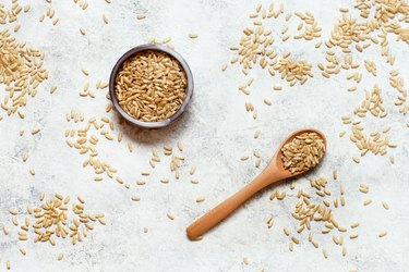 Brown rice in a wooden bowl with a  spoon