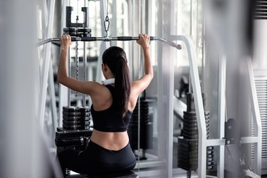 Woman exercise with lat pulldown machine in gym