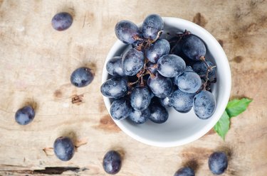 Black seedless grapes in a bowl on wooden