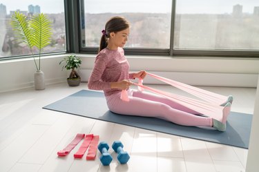 Woman performing at-home rowing workout.