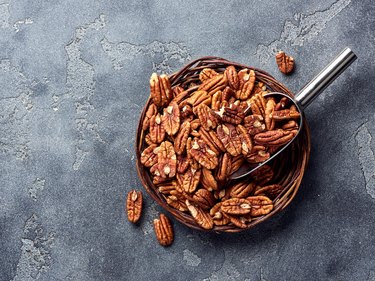 Pecan nuts and scoop on gray table