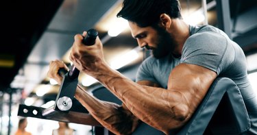 Young handsome man doing exercises in gym