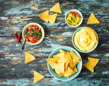 an overhead photo of tortilla chips and assorted dips