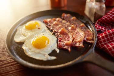 Fried bacon and eggs in an iron skillet