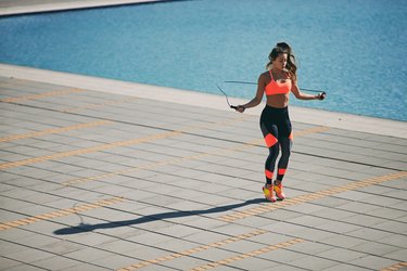 Person jumping rope outside to demonstrate the correct length a jump rope should be