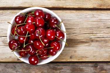 Cherries in bowl  on a wooden background.