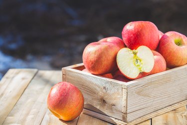 Red apples in wooden boxes on the table . Copy space.