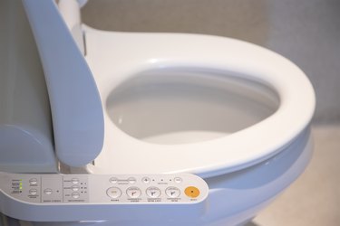 close view of a toilet with a bidet attachment