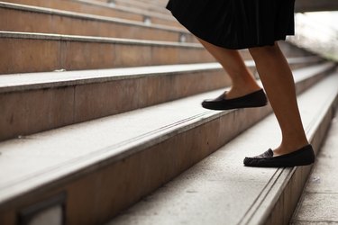 Low Section Of Woman Climbing On Steps