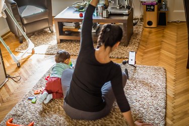 Mother exercising with her baby at home