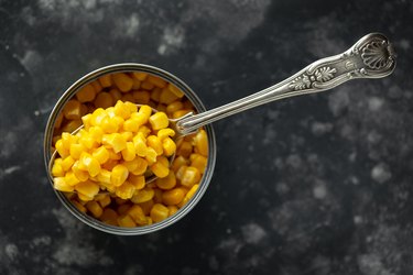 Sweet corn in an opened tin can with vintage spoon