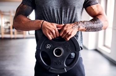 Midsection of young mixed race man doing exercise in gym.