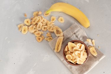 Banana - This is a close up shot of a bowl full of dried banana chips. Shot with a shallow depth of field and vignetting.