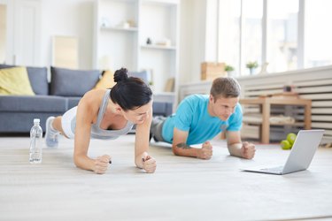 Man and woman working out in their hotel room