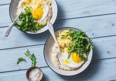 Low-FODMAP recipe oatmeal with fried egg and arugula on a blue background