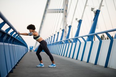 Runner athlete running at city bridge. Jogging and workout concept.
