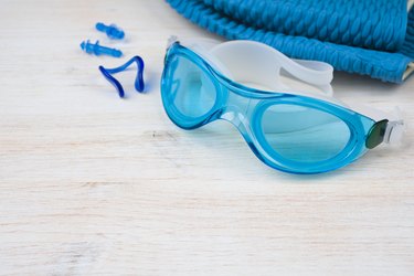 Blue swimming equipment on wooden background. Sport concept